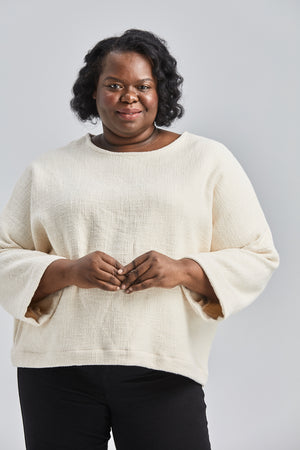 woman wearing a size small handwoven cream sweater with black pants