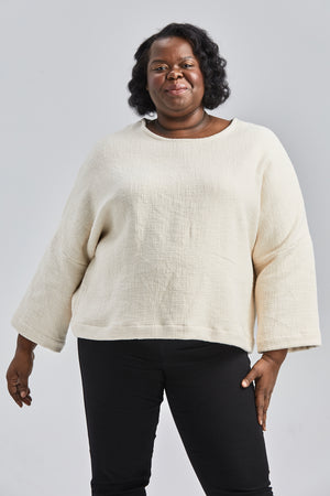 woman wearing a size medium handwoven cream sweater with black pants