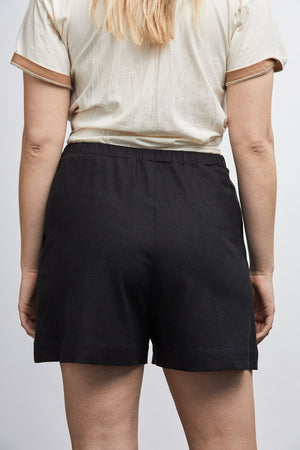 woman wearing green raw silk noil high waisted shorts and white tee shirt