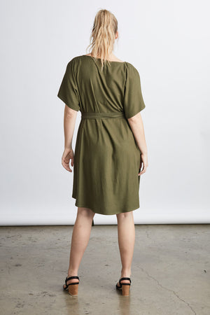 woman wearing a green raw silk noil belted knee length dress 