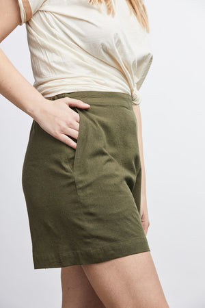 woman wearing green raw silk noil high waisted shorts and white tee shirt