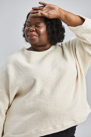 woman wearing a size small handwoven cream sweater with black pants