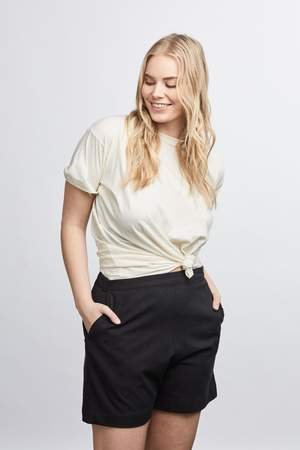 woman wearing green raw silk noil high waisted shorts and white tee shirt