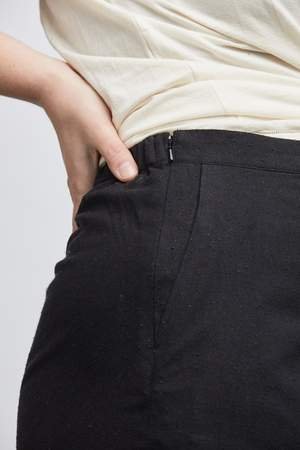 woman wearing green raw silk noil high waisted shorts and white tee shirt