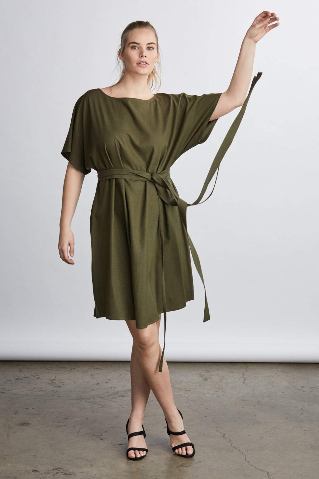 woman wearing a black raw silk noil belted knee length dress