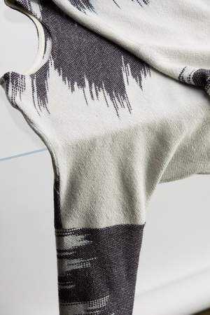 woman wearing a blue and white patterned hand woven oversized sweater with black pants