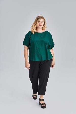 model wearing a white flowy raw silk noil blouse and black pants