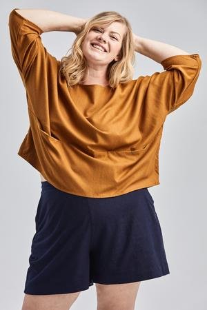 woman wearing green raw silk noil high waisted shorts and white tee shirt