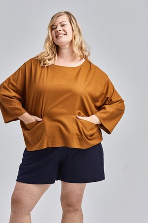 woman wearing green raw silk noil high waisted shorts and white tee shirt