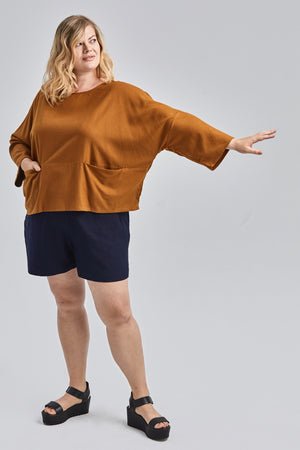 woman wearing green raw silk noil high waisted shorts and white tee shirt