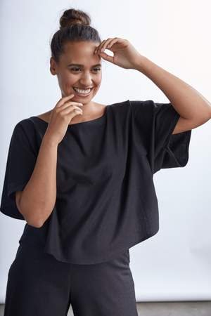 model wearing a white flowy raw silk noil blouse and black pants