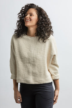 woman wearing a size small handwoven cream sweater with black pants